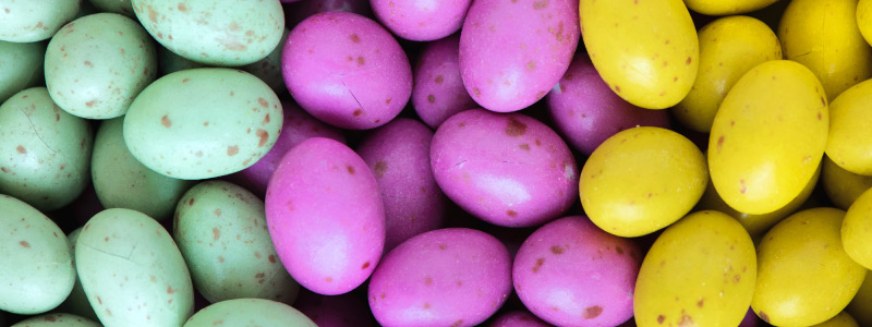 Mint green, purple, and yellow chocolate Easter candy eggs with brown speckles