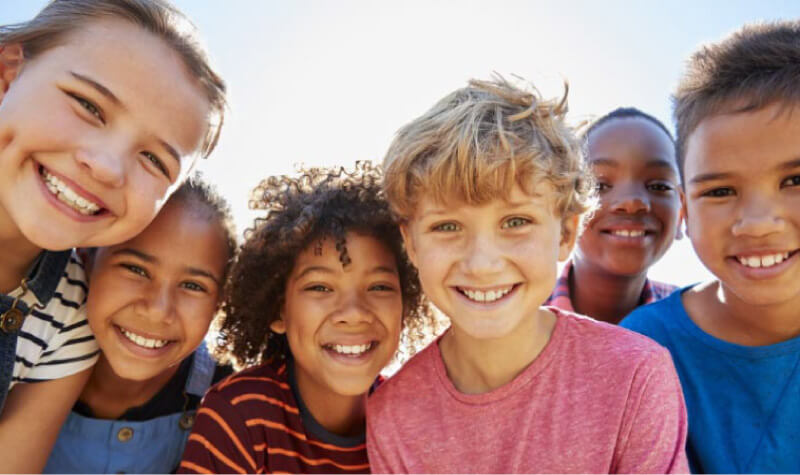 group of kids back to school showing off their bright smiles