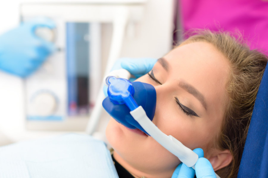 Woman in the dental chair with a mask to administer nitrous oxide to control dental anxiety.
