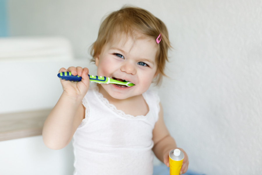 Toddler girl brushing her teeth.